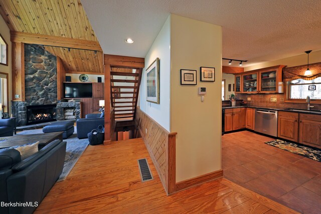 55 Mallard Dr, Becket, MA 01223 - kitchen with dishwasher, open floor plan, dark countertops, brown cabinetry, and glass insert cabinets