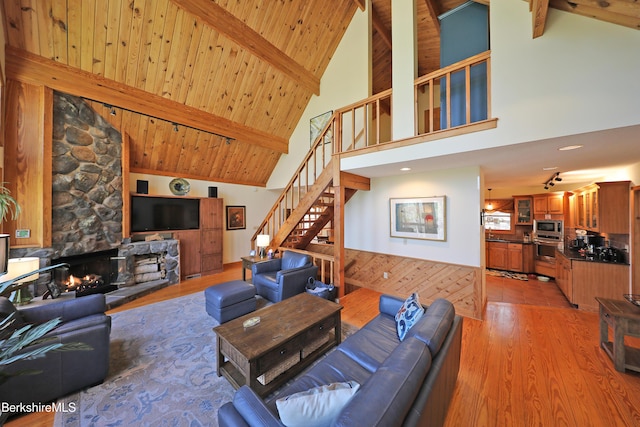 55 Mallard Dr, Becket, MA 01223 - living area with high vaulted ceiling, stairway, a fireplace, light wood-style flooring, and a wooden ceiling with exposed beams
