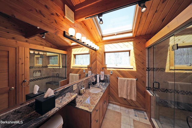 55 Mallard Dr, Becket, MA 01223 - full bath with wooden walls, vanity, a skylight, tile patterned flooring, and a shower stall