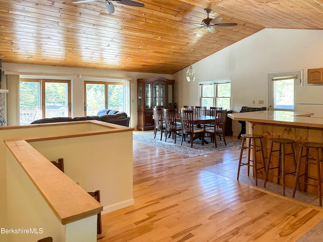 dining room featuring ceiling fan, wooden ceiling, vaulted ceiling, and light wood-type flooring