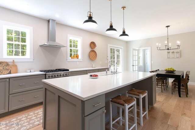 60 Parsley Ln, Sheffield, MA 01257 - kitchen featuring gray cabinetry, wall chimney exhaust hood, light wood-style floors, and a chandelier