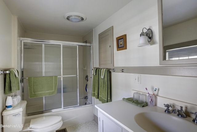 full bathroom featuring vanity, toilet, and bath / shower combo with glass door