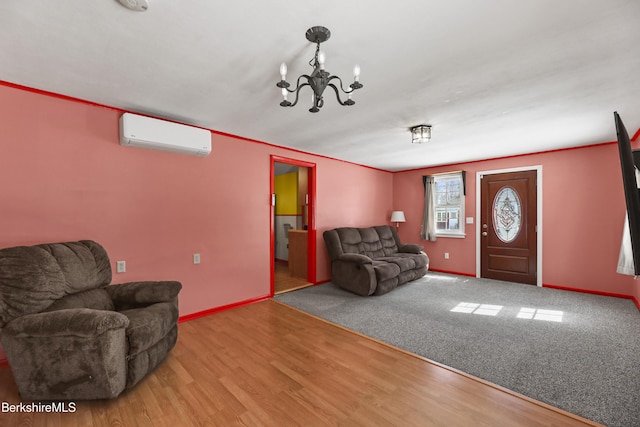 living area with an AC wall unit, baseboards, an inviting chandelier, and wood finished floors