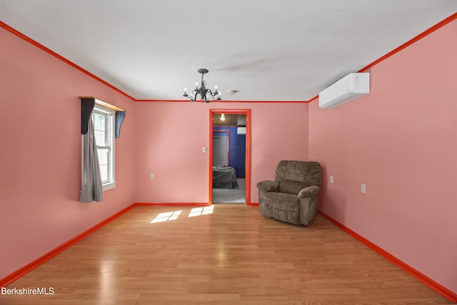 unfurnished room featuring light wood finished floors, baseboards, crown molding, an AC wall unit, and a chandelier