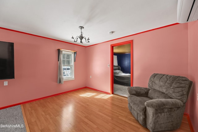 living area with an inviting chandelier, baseboards, and wood finished floors