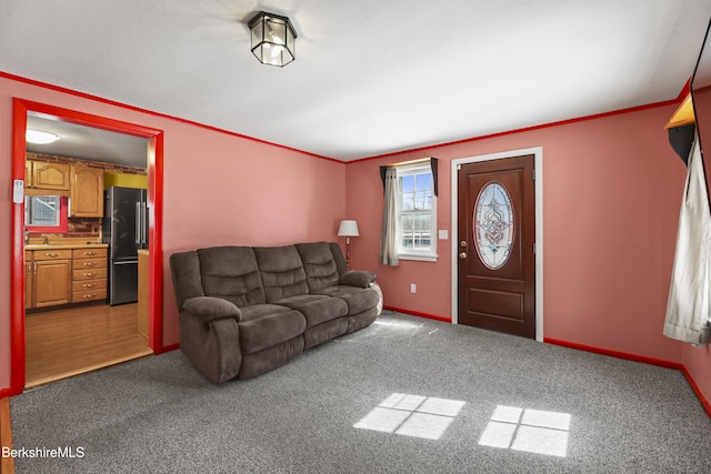 living area featuring ornamental molding, carpet flooring, and baseboards