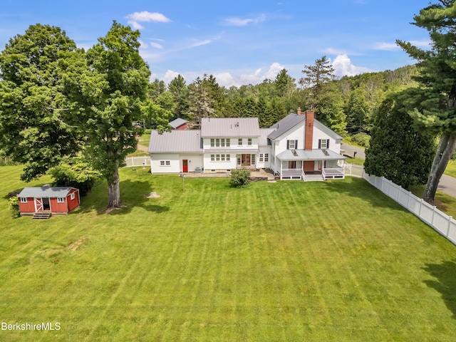 rear view of house with a yard and an outdoor structure