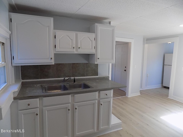 115 Commercial St, Adams, MA 01220 - kitchen with dark countertops, a sink, freestanding refrigerator, white cabinetry, and tasteful backsplash
