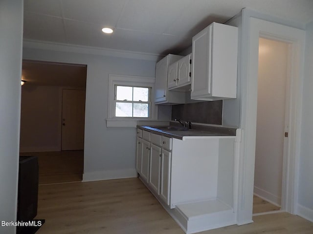 115 Commercial St, Adams, MA 01220 - kitchen with white cabinetry, baseboards, a sink, and light wood-style flooring