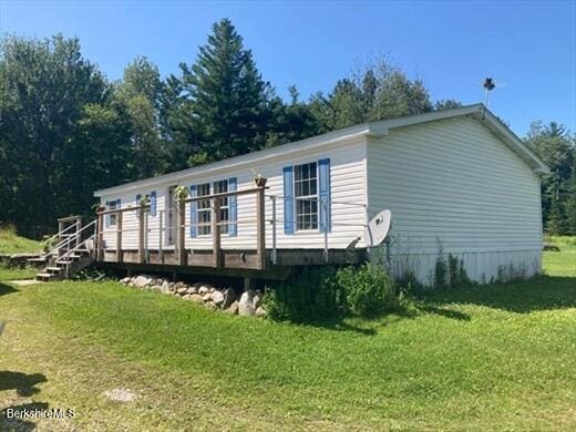 view of property exterior featuring a wooden deck and a yard