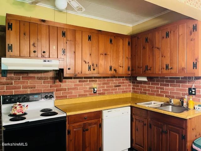 kitchen with backsplash, crown molding, sink, and white appliances