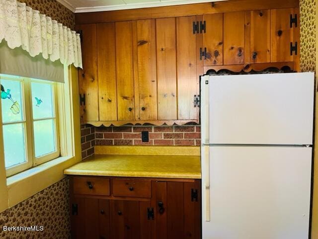 kitchen featuring white fridge and crown molding