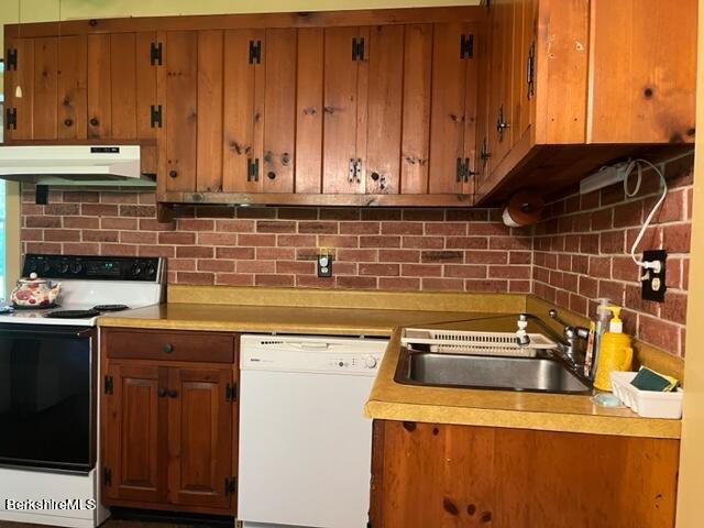 kitchen with backsplash, sink, and white appliances