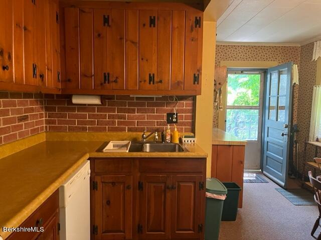 kitchen featuring light carpet, white dishwasher, and sink