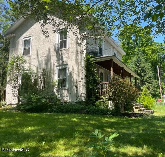 view of side of home with a lawn