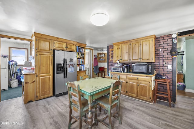 kitchen with stainless steel refrigerator with ice dispenser, white fridge, and light hardwood / wood-style flooring