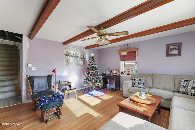 living room with hardwood / wood-style floors, beam ceiling, and ceiling fan