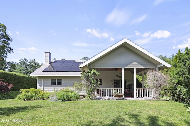 83 Hancock Rd, Pittsfield, MA 01201 - view of front of property featuring a chimney, roof mounted solar panels, a front yard, and a porch