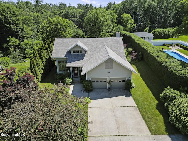 83 Hancock Rd, Pittsfield, MA 01201 - view of front of house featuring roof with shingles, driveway, a wooded view, and a chimney