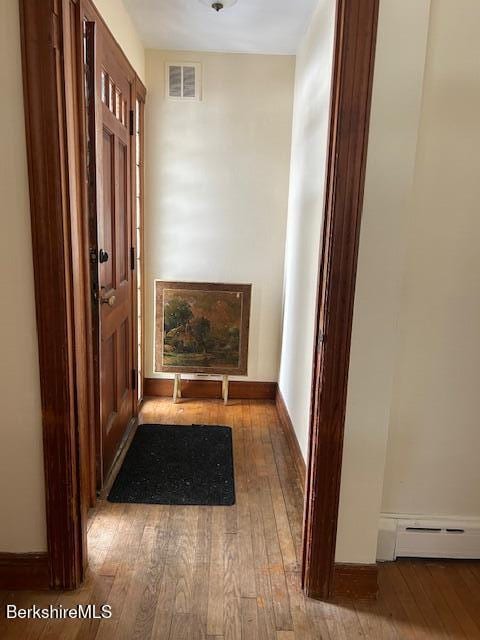 hallway featuring hardwood / wood-style floors and a baseboard heating unit