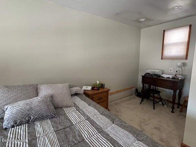 carpeted bedroom with a baseboard heating unit