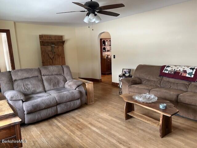 living room featuring light hardwood / wood-style flooring and ceiling fan