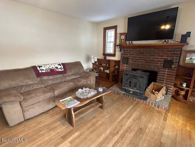 living room with a wood stove and hardwood / wood-style floors