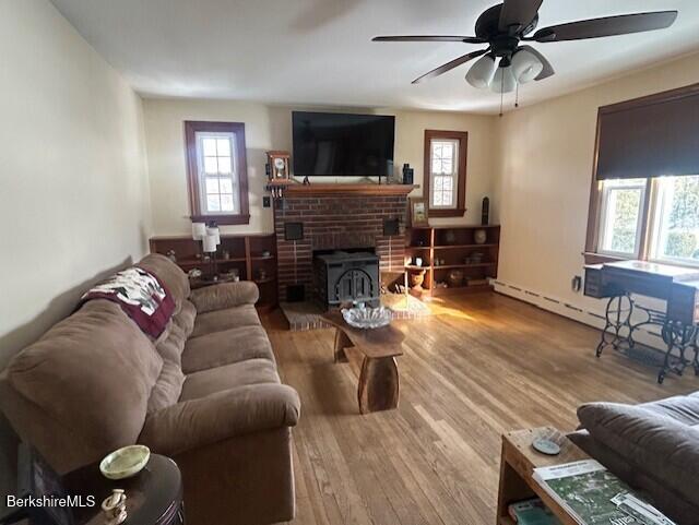 living room with wood-type flooring, a wealth of natural light, and ceiling fan