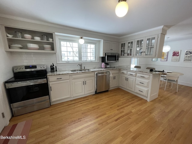 kitchen with white cabinetry, appliances with stainless steel finishes, sink, and light hardwood / wood-style flooring