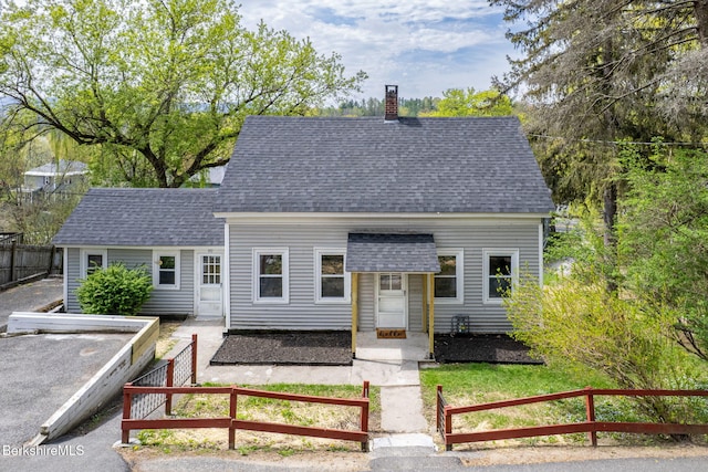90 Maple St, Lee, MA 01238 - view of front facade featuring a shingled roof and a chimney