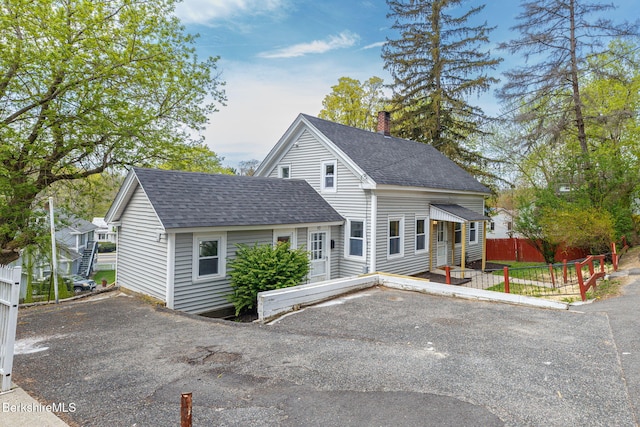 90 Maple St, Lee, MA 01238 - view of front of house featuring roof with shingles, a chimney, and fence