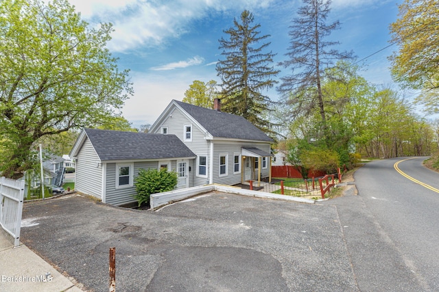 90 Maple St, Lee, MA 01238 - view of front facade with fence, a shingled roof, and a chimney
