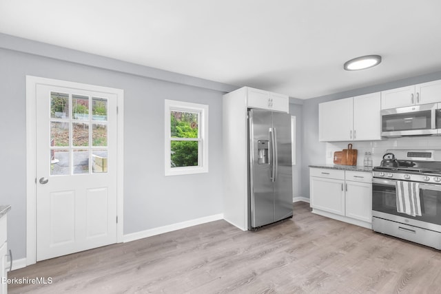 90 Maple St, Lee, MA 01238 - kitchen with appliances with stainless steel finishes, white cabinetry, light wood-type flooring, and backsplash