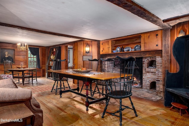 196 S St, Williamstown, MA 01267 - dining room featuring light wood-style floors, wood walls, a chandelier, beamed ceiling, and a fireplace