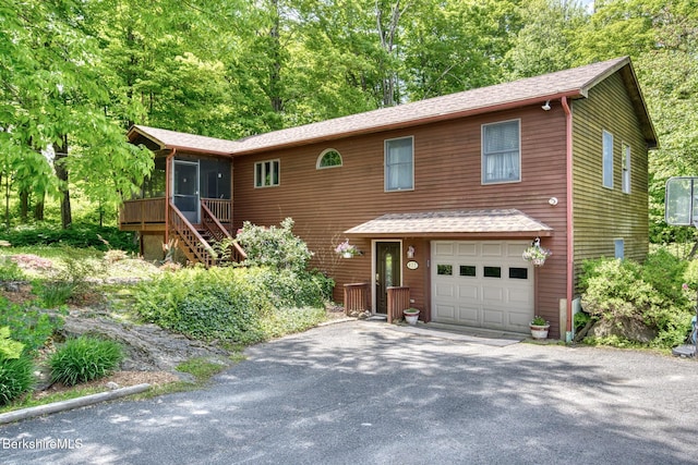 477 Greylock St, Lee, MA 01238 - rustic home featuring an attached garage, a sunroom, asphalt driveway, stairs, and a shingled roof