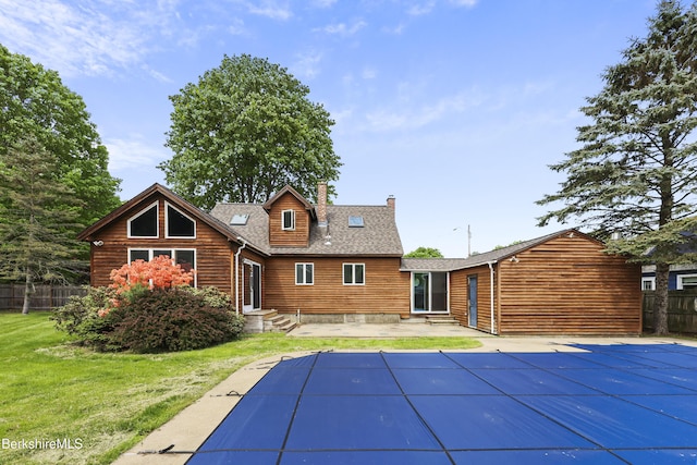 back of property with a chimney, roof with shingles, a patio, and entry steps