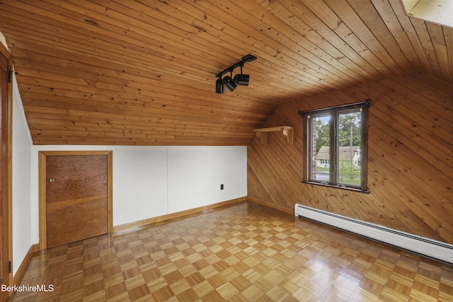additional living space with vaulted ceiling, a baseboard heating unit, wood walls, wood ceiling, and baseboards