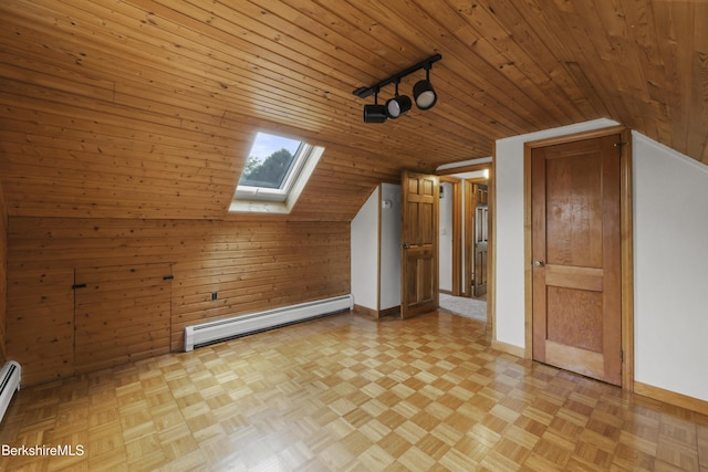 bonus room featuring baseboard heating, a skylight, vaulted ceiling, wooden walls, and baseboards