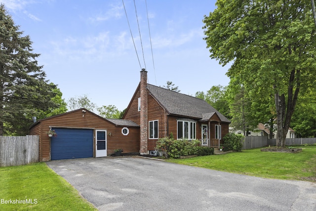chalet / cabin featuring an attached garage, asphalt driveway, a chimney, and roof with shingles