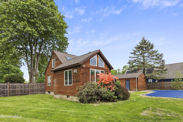 view of side of property featuring a shingled roof and an outbuilding