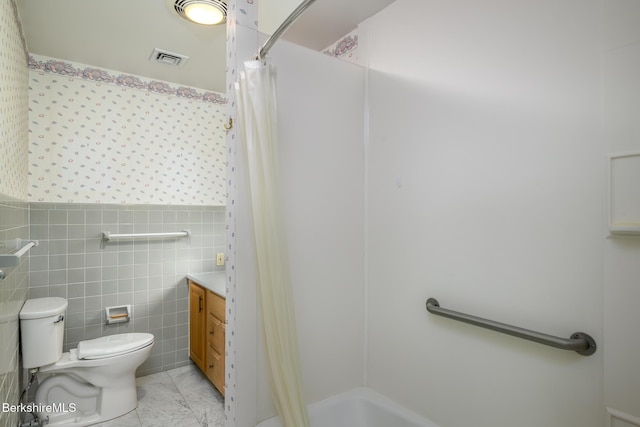 full bathroom with a shower with curtain, toilet, tile walls, wainscoting, and vanity