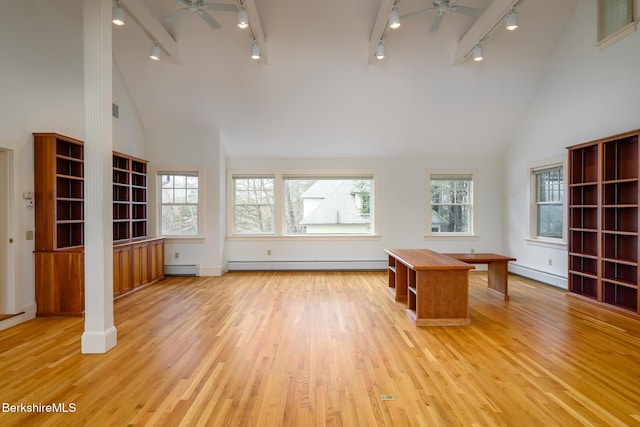 unfurnished office with a baseboard heating unit, light wood-style flooring, a healthy amount of sunlight, and a ceiling fan