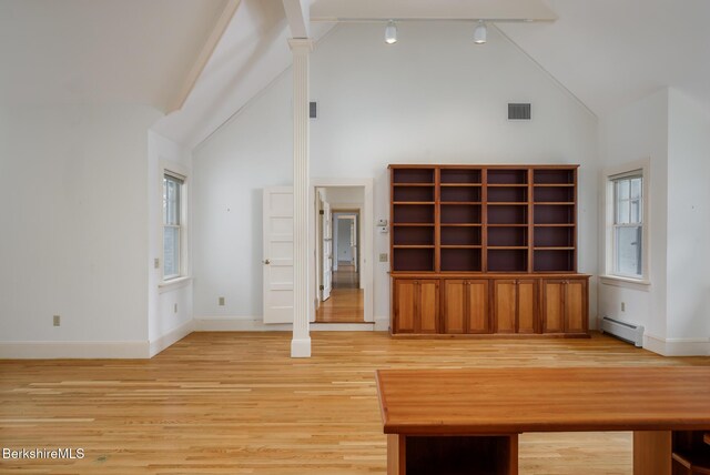 interior space with visible vents, high vaulted ceiling, a baseboard heating unit, light wood-style floors, and baseboards