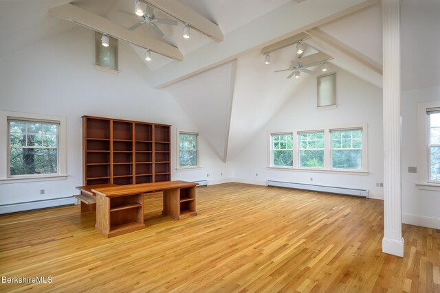 unfurnished office featuring a baseboard heating unit, vaulted ceiling with beams, and a ceiling fan