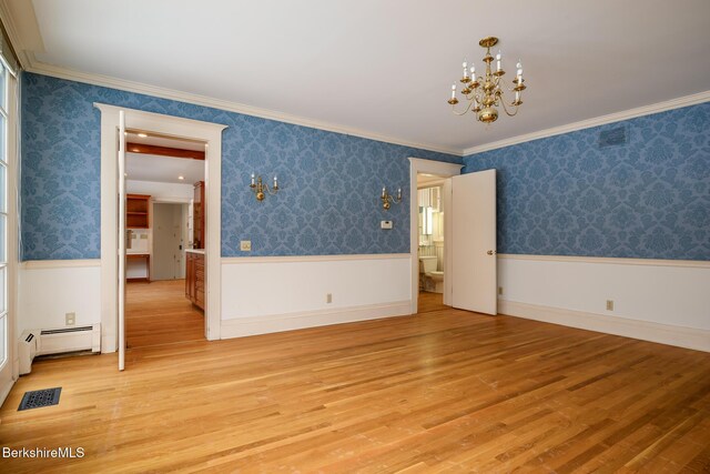 spare room featuring a wainscoted wall, a baseboard radiator, wallpapered walls, an inviting chandelier, and light wood-style floors