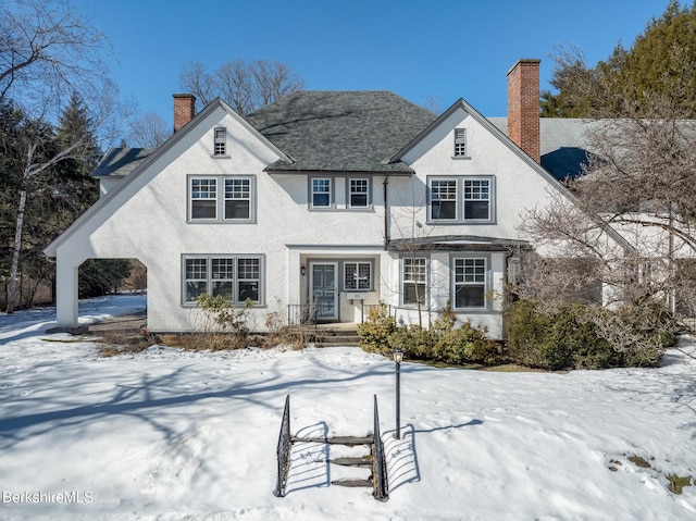 view of front of property with stucco siding and a chimney