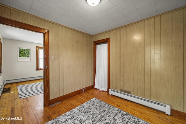 41 Pine St, Dalton, MA 01226 - unfurnished room featuring a baseboard radiator, hardwood / wood-style floors, wood walls, and baseboards