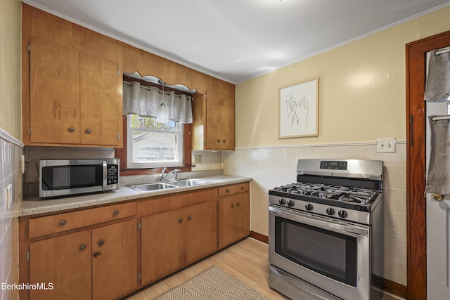 41 Pine St, Dalton, MA 01226 - kitchen featuring stainless steel appliances, a sink, light wood-style flooring, tile walls, and crown molding