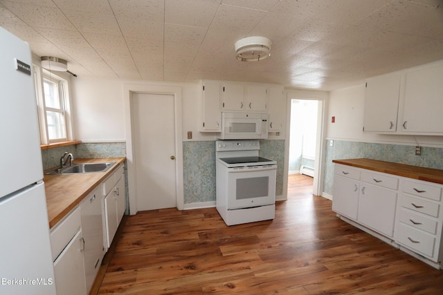 kitchen with wood finished floors, white appliances, butcher block counters, and a sink