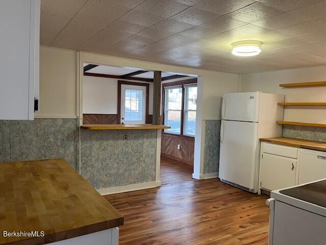 kitchen featuring dark wood-style floors, white appliances, wainscoting, and butcher block counters